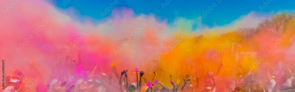 Crowd throwing bright coloured powder paint in the air, Holi Festival Dahan.