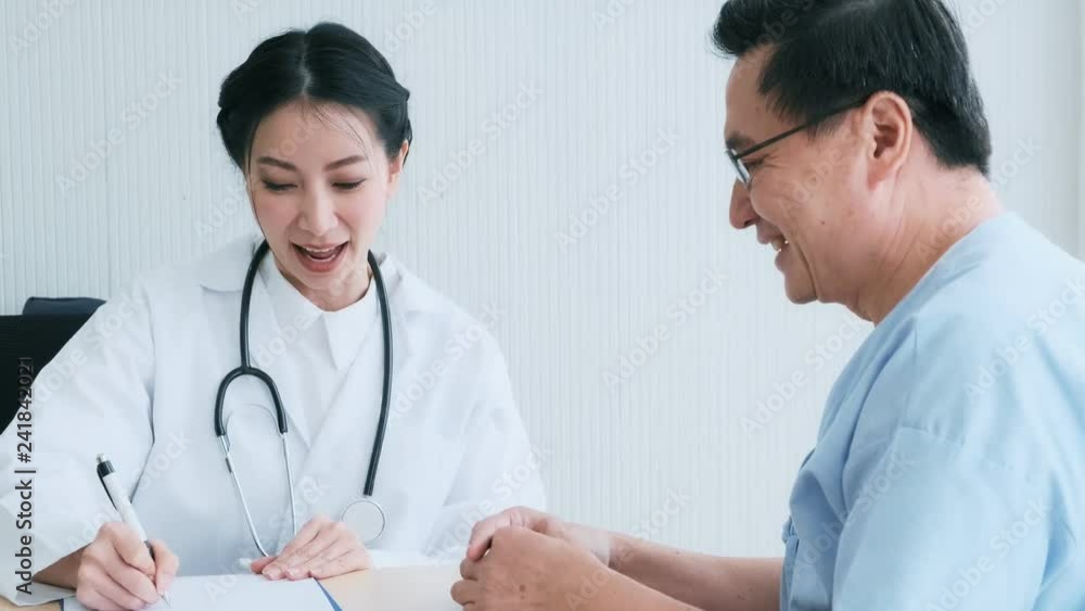 Doctor with patient. Young female medical doctor talking to a senior patient at hospital. Taking notes to discuss medical examination result. Senior care medical and insurance concept. Doctor with patient. Young female medical doctor talking to a senior patient at hospital. Taking notes to discuss medical examination result. Senior care medical and insurance concept.