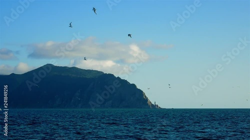 High rocky Cape Aniva on Sakhalin Island with sea lighthouse. photo