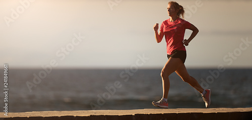 Woman running on beach in morning sunrise  fitness workout sport