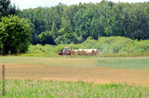 Tractor in the field, landscape of Mazurian region in Poland.