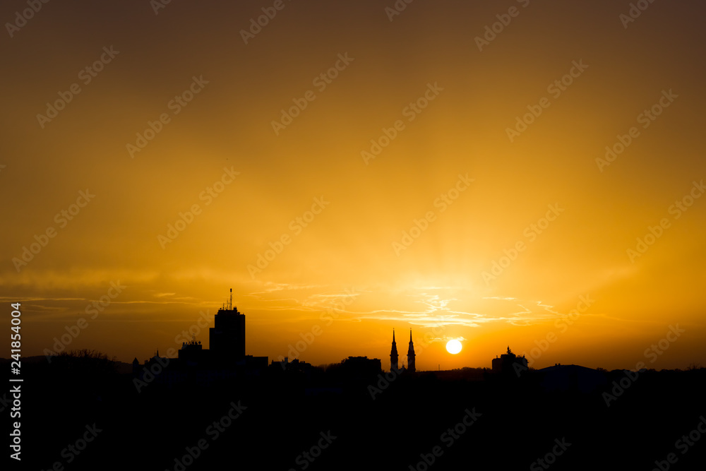 Beautiful sunset sky, evening cityscape. Silhouette of the buildings over colorful cloudy sky background