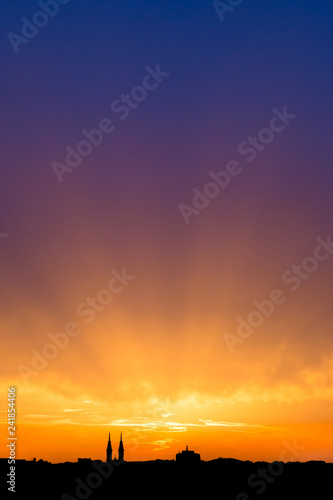 Beautiful sunset sky, evening cityscape. Silhouette of the buildings over colorful cloudy sky background