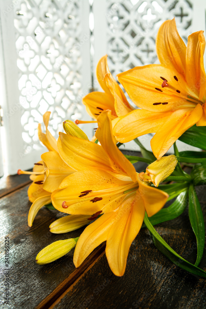 Fototapeta premium Sensual bouquet of beautiful orange lilies flowers close up