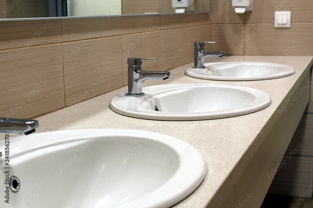three white sinks in the toilet room three white sinks in the toilet room