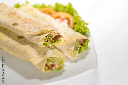 Fresh tortilla wraps with vegetable filling and chicken - close up
