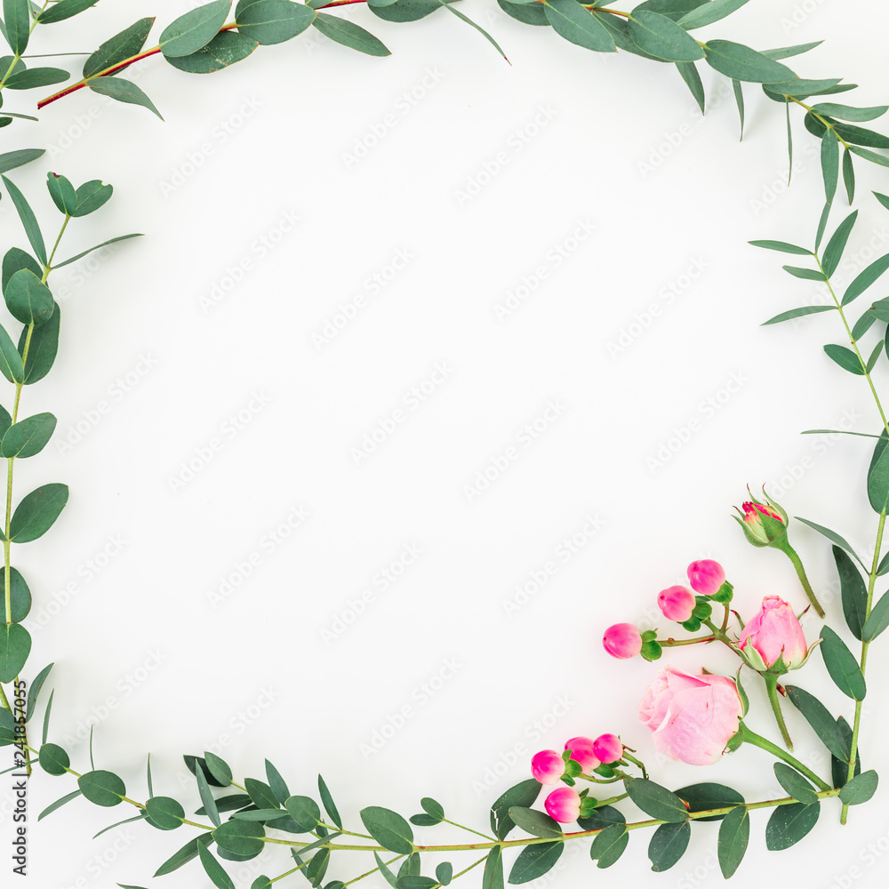 Naklejka premium Flower frame of pink roses and eucalyptus branches on white background. Flat lay, top view
