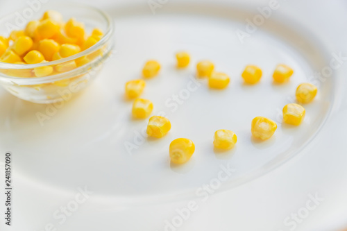 Close up of sweet corn in shape of heart  on white plate.