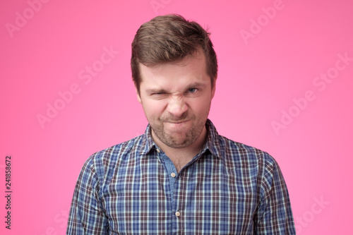 Canvas Print Portrait of an angry man on pink backfround.