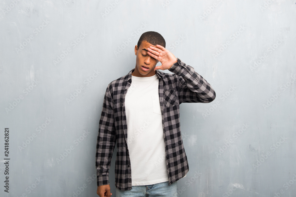 Young african american man with checkered shirt with tired and sick expression