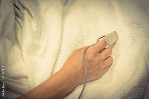 Close-up pulse oximeter in a lady patient fingertip for heart rate and blood oxygen level monitoring at labor and delivery room