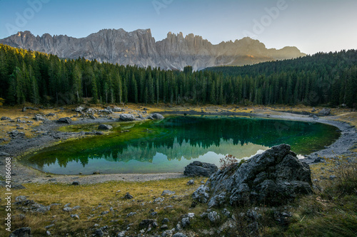 Reflection of Latemar in the clear water of Lake Carezza Karersee in Dolomite Alps, Trentino Alto Adige, South Tirol, Italy photo