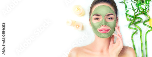 Fototapeta Naklejka Na Ścianę i Meble -  Spa. Young woman applying facial green clay mask in spa salon. Beauty treatments. Skincare. Top view