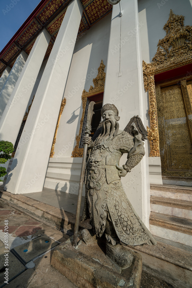 Chinese guardian figure beside a gate in Wat Pho