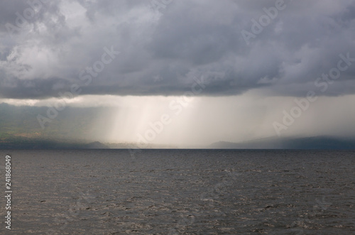 Clouds and rain in the ocean near a tropical island