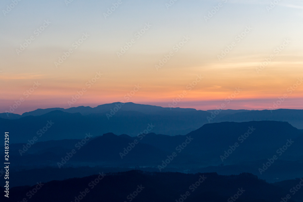 Sunrise view over mountains from a mountain peak. Mountains silhouette. Nature landscape.