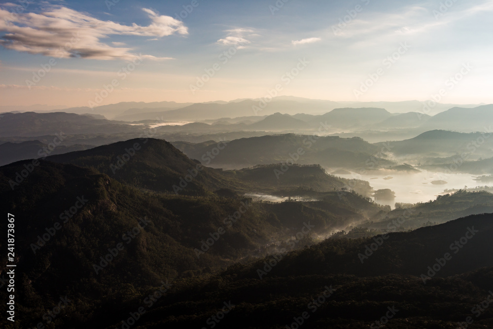 View over mountain from a mountain peak. Panorama view over mountains and lake. Misty morning just after sunrise. Nature landscape. View over mountain from a mountain peak. Panorama view over mountains and lake. Misty morning just after sunrise. Nature landscape.