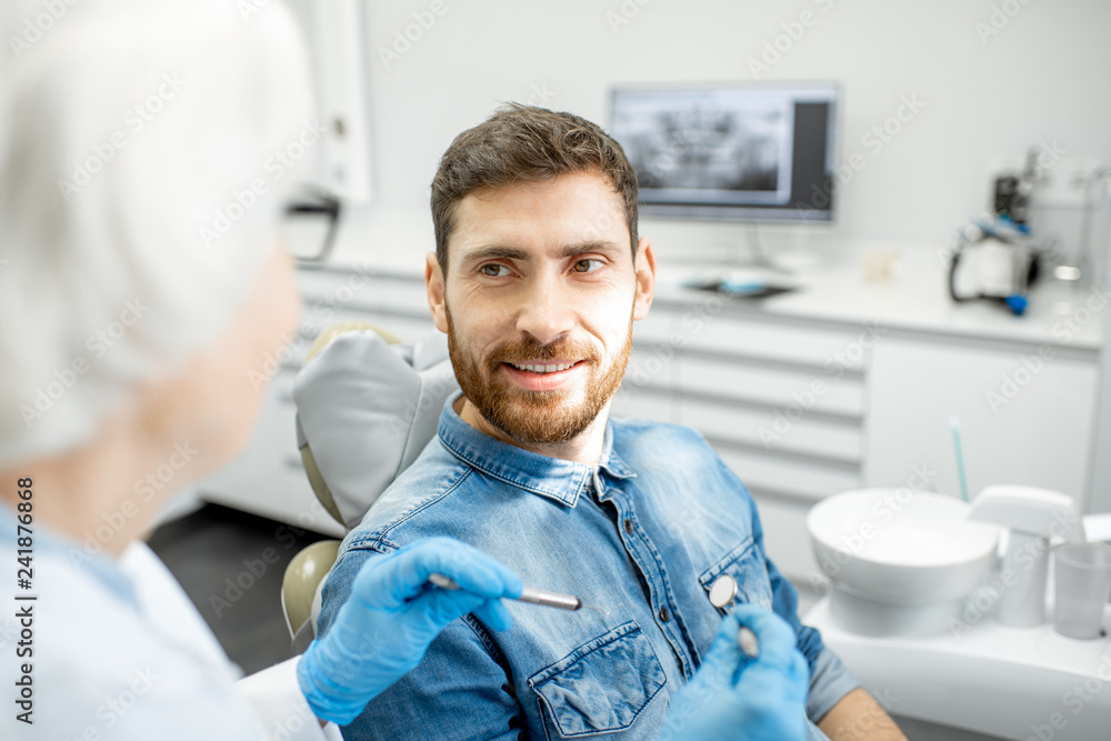 Obraz premium Handsome man during the dental consultation with elderly woman dentist in the dental office