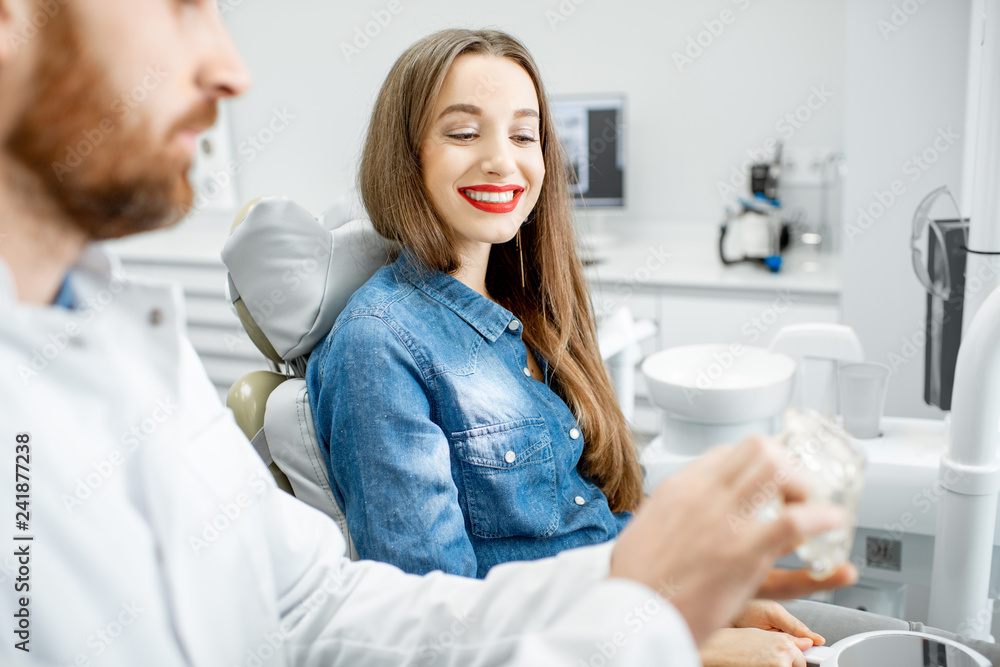 Fototapeta premium Young beautiful woman during the medical consultation with male dentist in the dental office