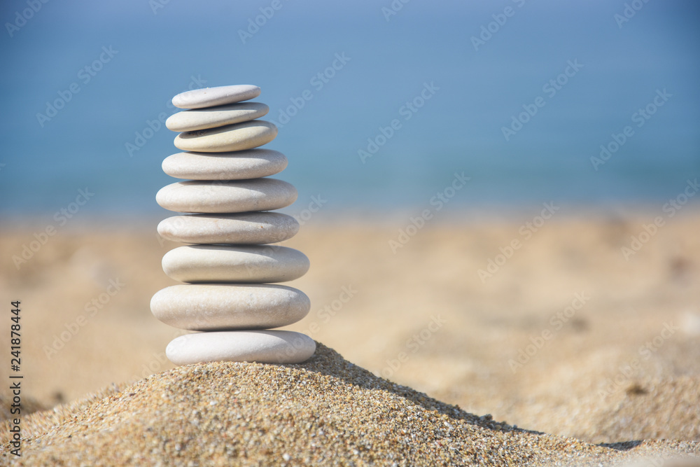 Balanced stone pyramid on sand on beach. Zen rock, concept of balance and harmony Balanced stone pyramid on sand on beach. Zen rock, concept of balance and harmony