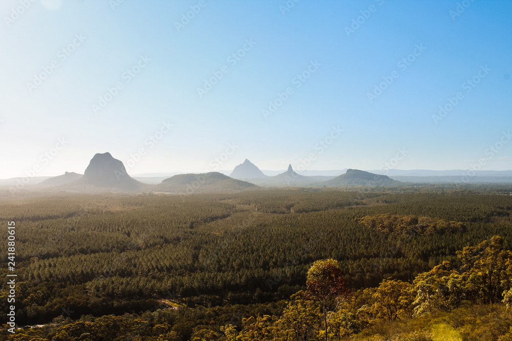 Fototapeta premium Panorama of Glass House Mountains with fog covering the picturesque mountains during daytime (Brisbane area, Queensland, Australia)