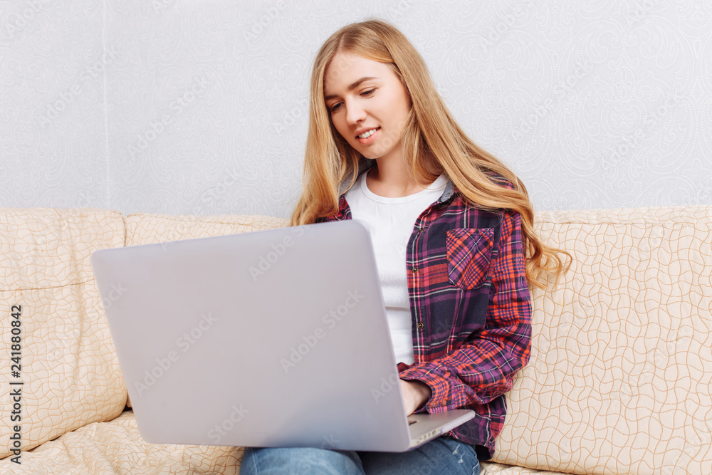 Happy girl with laptop chatting, sitting on sofa at home, concept of communication and technology. Happy girl with laptop chatting, sitting on sofa at home, concept of communication and technology.