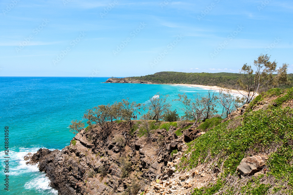Waves hitting cliffs during hike through Noosa National Park during a clear summer day in Noosa Heads (Queensland, Australia)