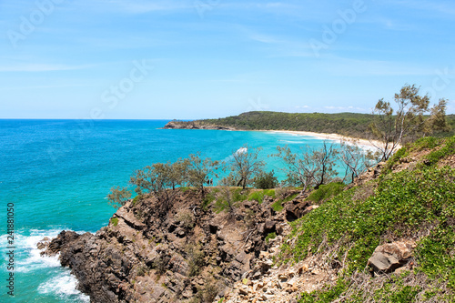 Waves hitting cliffs during hike through Noosa National Park during a clear summer day in Noosa Heads (Queensland, Australia)