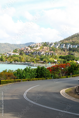 City views of Airlie Beach with road in foreground and holiday houses as background (Airlie Beach, Queensland, Australia)