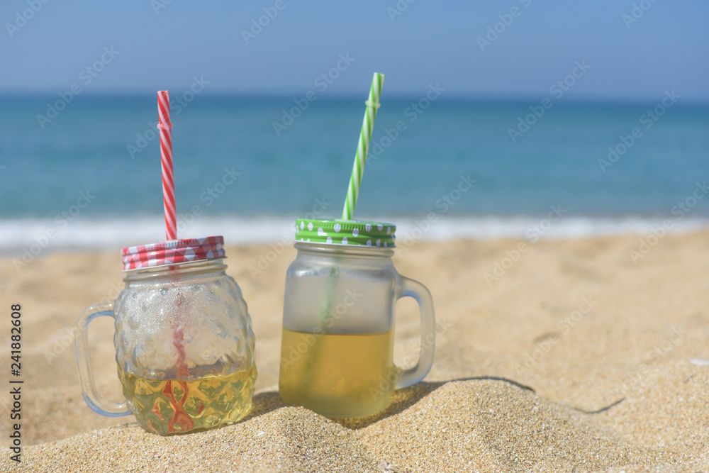 Cold refreshment on sandy beach.  Summer holidays background, concept of summer vacation