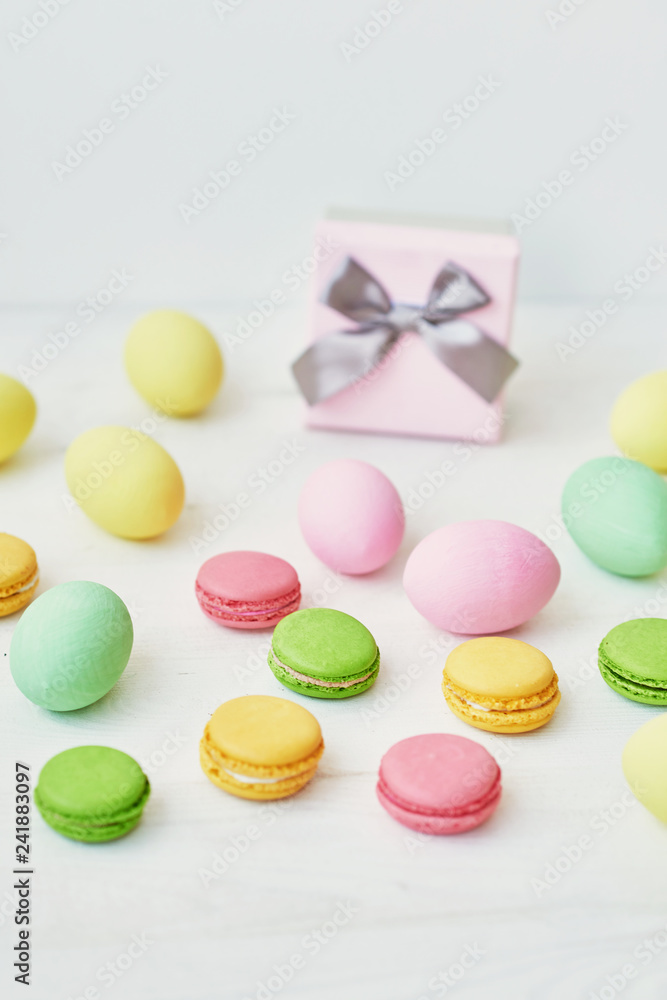 Spring and Easter holiday concept with copy space. Template Easter Greeting Card. Easter decoration with eggs and gift box. Macarons with Easter eggs background Spring and Easter holiday concept with copy space. Template Easter Greeting Card. Easter decoration with eggs and gift box. Macarons with Easter eggs background