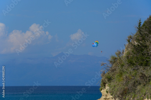 people are flying with a parachute (parasailing)