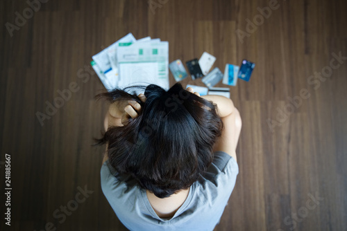 Top view of stressed young Asian woman hands holding the head trying to find money to pay credit card debt and all loan bills Fototapet