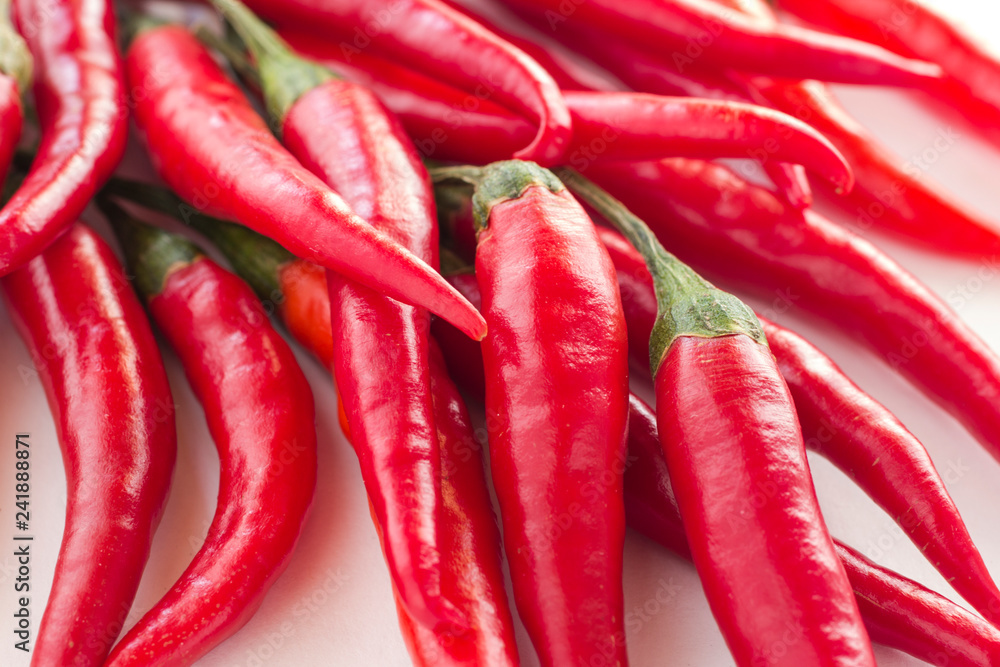 Red chili pods with green stems on a white background Red chili pods with green stems on a white background