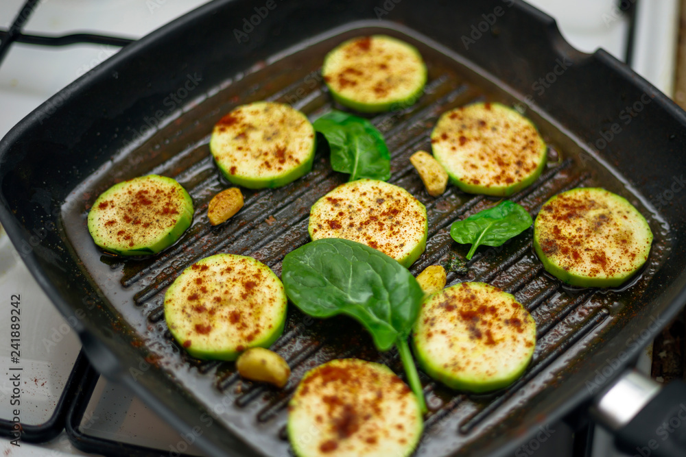grilled zucchini with powdered paprika and spinach in a grill pan grilled zucchini with powdered paprika and spinach in a grill pan