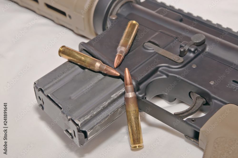 The upper of a black and brown 223 caliber AR-15 rifle with a magazine
