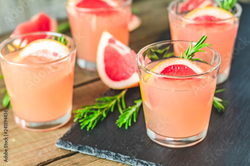 Pink cocktail with grapefruit, ice and rosemary