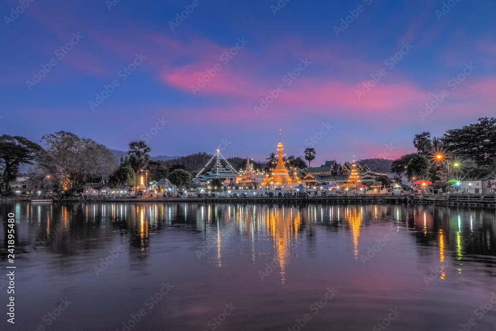 Lake view evening of Wat Chong Klang and Wat Chong Kham Chedi Myanmar style art with reflection on the surface of water and colorful twilight vivid sky background, Mae Hong Son, northern of Thailand.