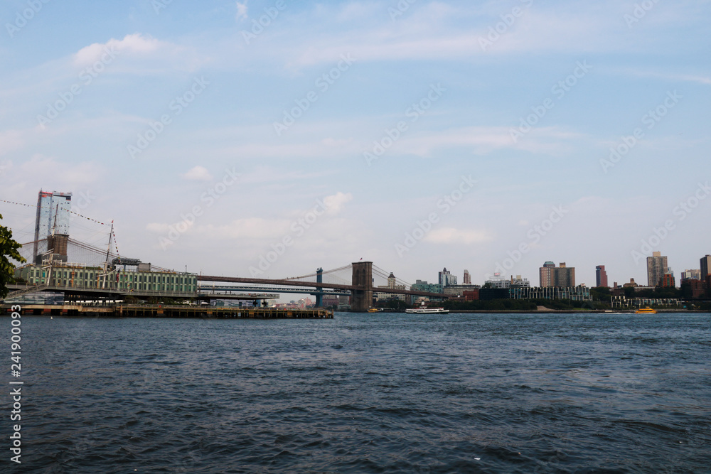 New York, USA - September 2, 2018: Brooklyn Bridge with the skyline of Downtown Manhattan on cloudy sky.