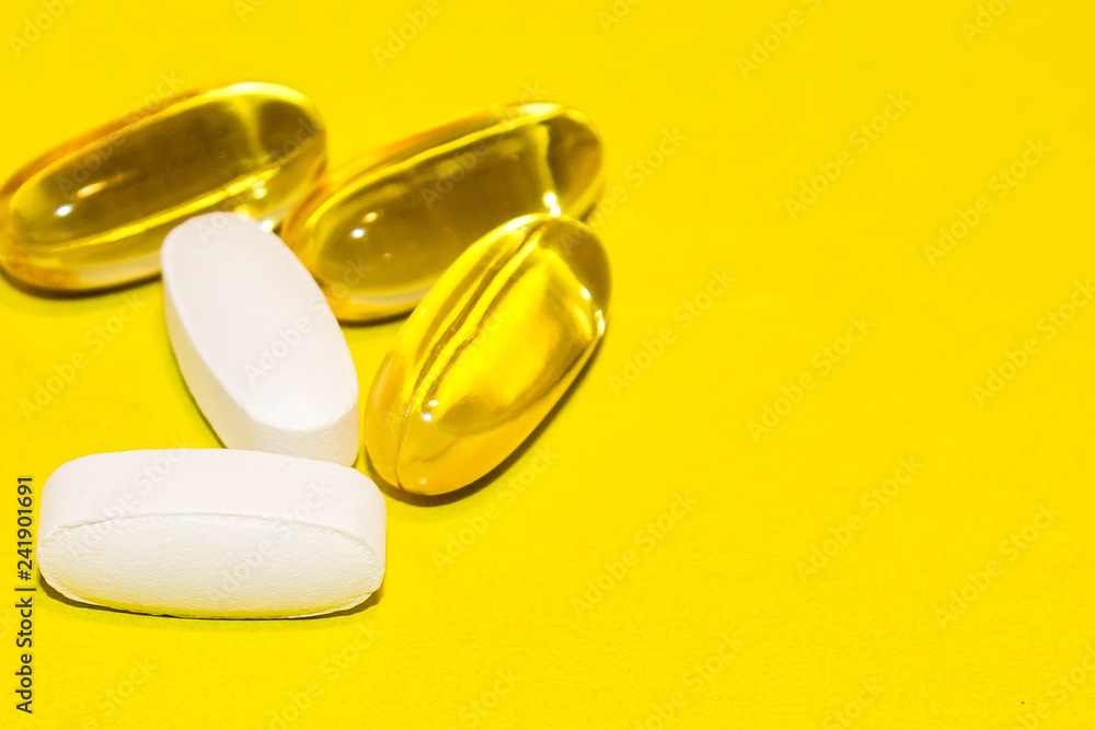 colorful medical pills, on yellow background, closeup colorful medical pills, on yellow background, closeup