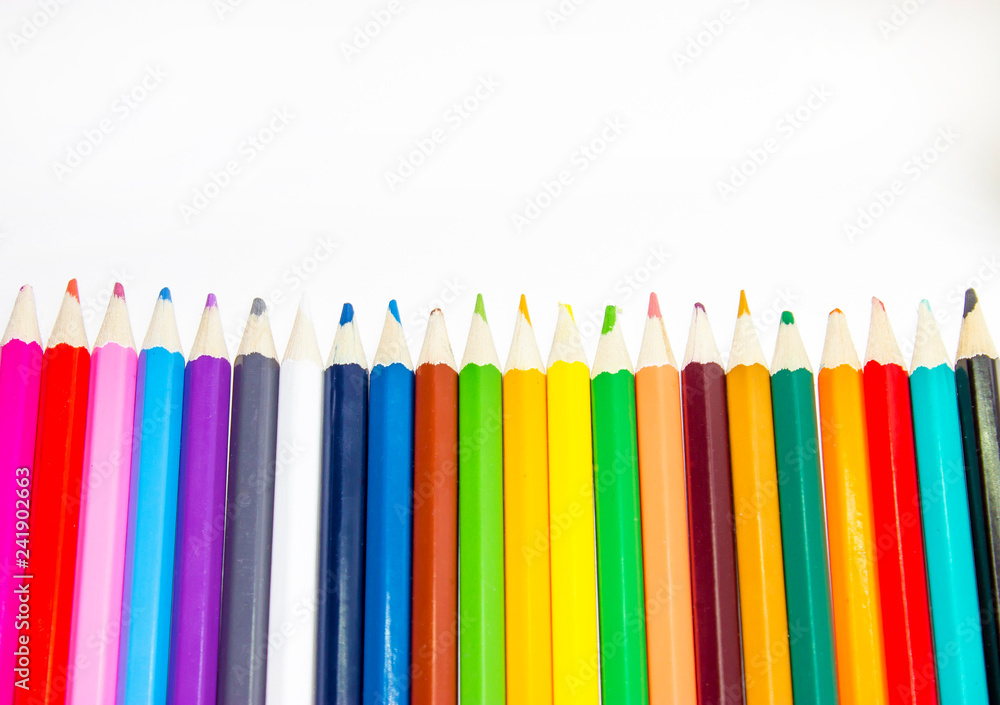 School supplies, colored pencils in a row, isolated, closeup School supplies, colored pencils in a row, isolated, closeup