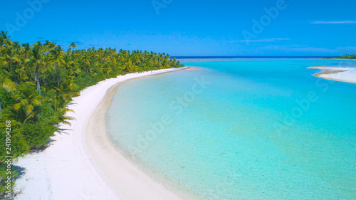 DRONE: Flying above the turquoise ocean water and along the sandy shoreline. © helivideo