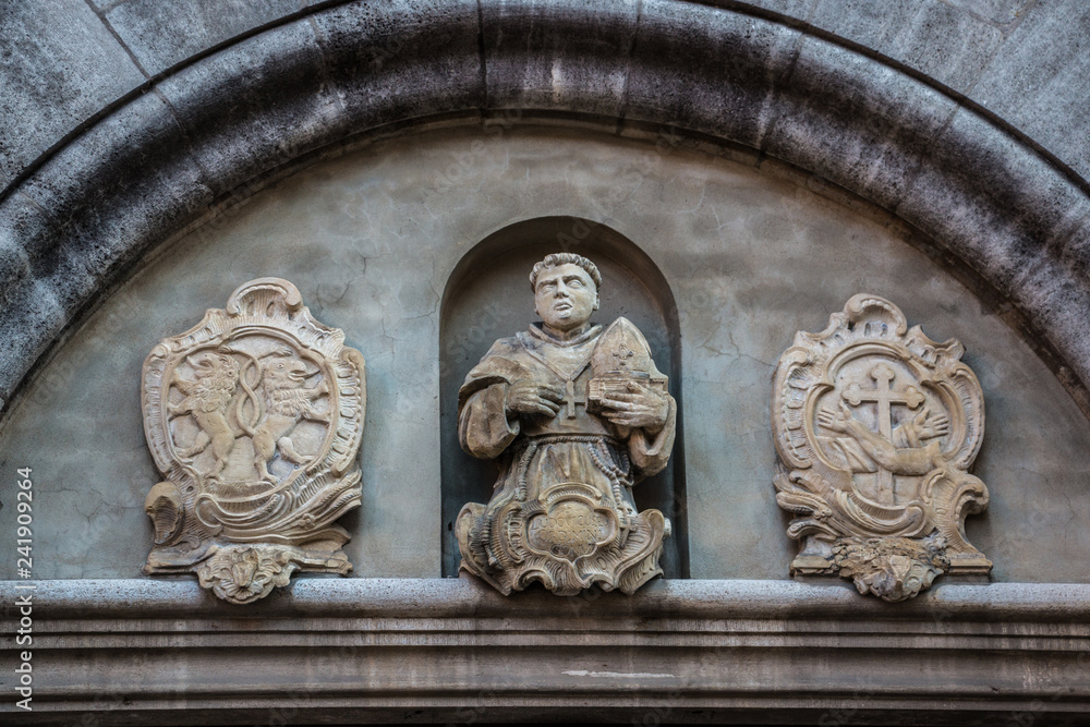 Beautiful coat of arms and statue on a historical old building