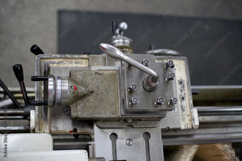 Lathe machine for metal cutting, machinery center background.
