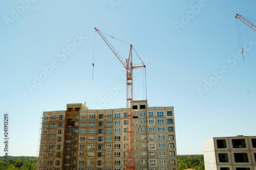 Constructions cranes near building. Construction site with crane and building. © Sunny