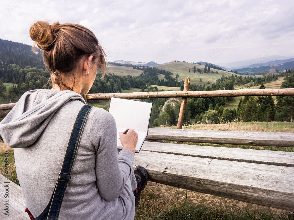 Woman artist working outdoors in mountains