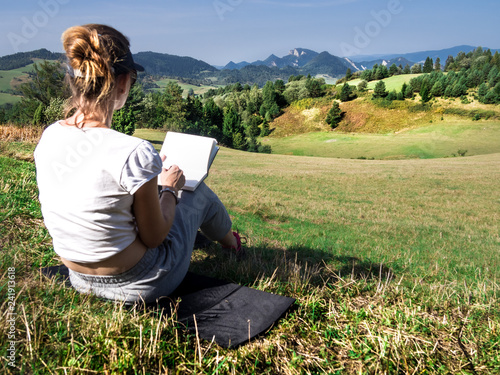 Woman artist working outdoors on hillside