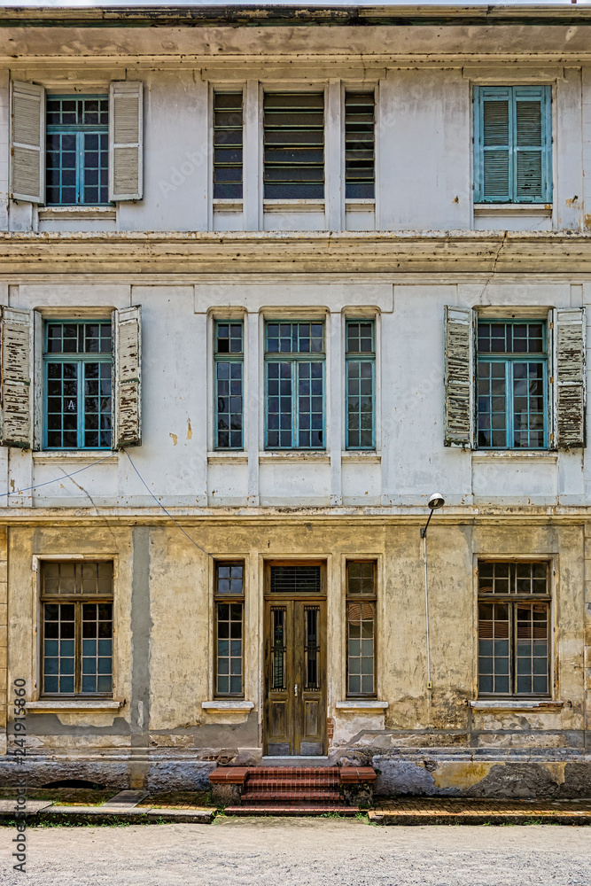 Obraz premium Facade of old building with wooden door and wooden windows with glass