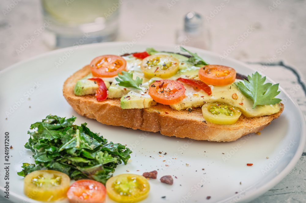 Toasted Bread Sandwich with Avocado and Tomatoes Served with Green Kale