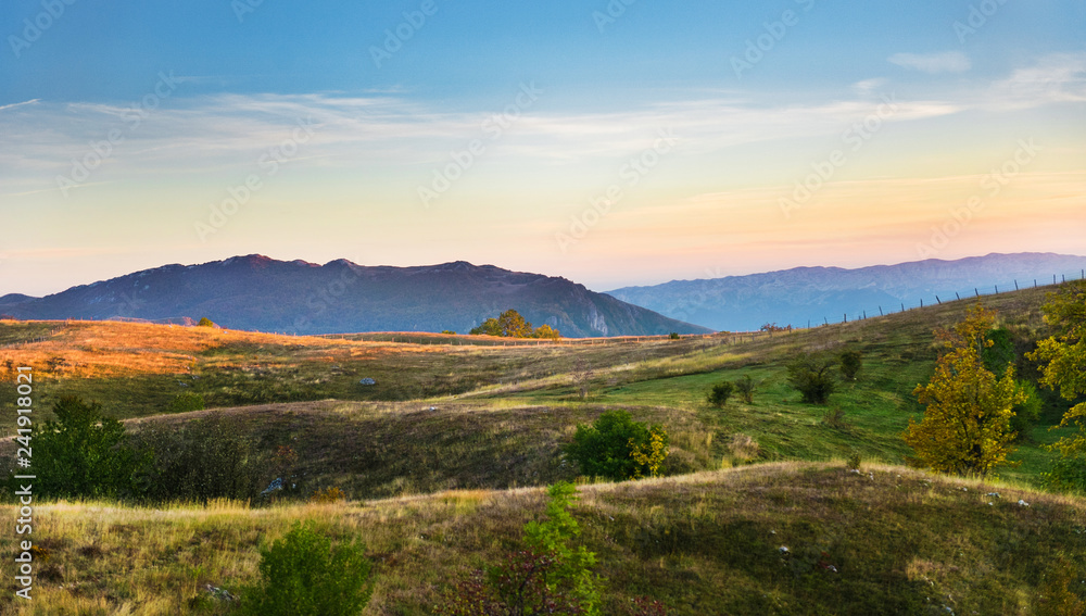 Mountains view with hills and pastel colors sky and mountains background, Durmitor on the way to Black Lake - Crno Lake, from Zhablyak, beauty sunset orange colors
